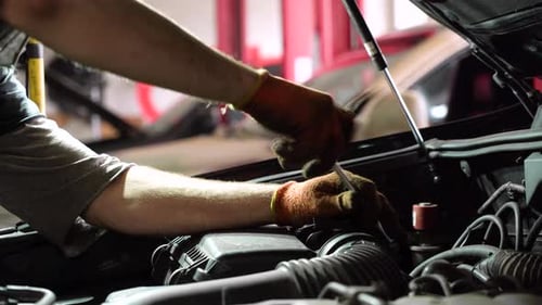 Auto mechanic repairs SUV engine. auto repair station. close-up