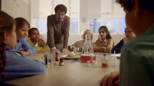 Teacher Demonstrating Science Experiment to Group of Children