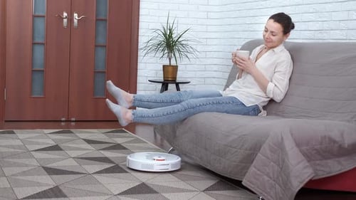 Woman Relaxes as Robot Vacuum Cleans Home