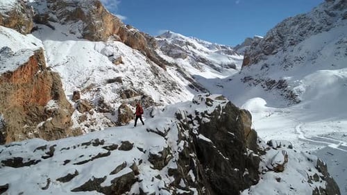 Adult Hiker Exploring Snowy Mountain Range in Winter