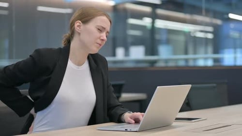 Woman with Back Pain Working at Laptop