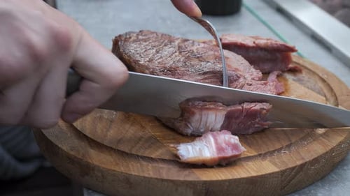 Slicing Cooked Steak on Wooden Cutting Board