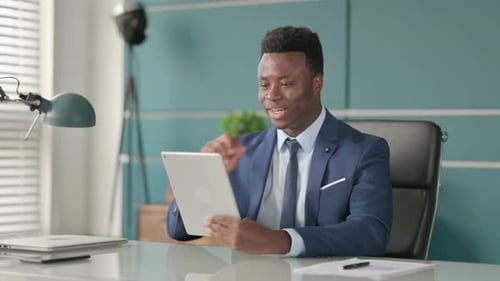 African Businessman Making Video Call on Tablet in Office