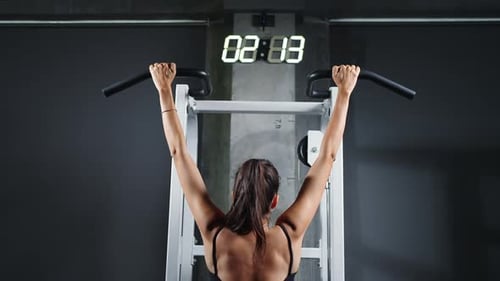 4K Confidence Latin woman pulling up body weight lifting at gym.