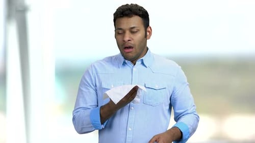 Man Coughing and Sneezing into Tissue