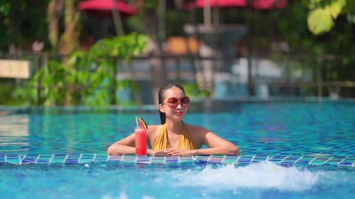Young asian woman enjoy around outdoor swimming pool for leisure