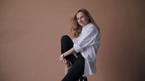 Elegant Professional Model in the White Shirt Posing to a Camera in the Studio