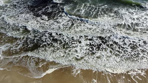 Aerial Drone View Flight Over Sea Waves That Roll Onto Sandy Shore