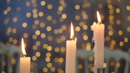Close-up View of Burning Candles on a Background of Blurry Flickering Lights. Bright Beautiful