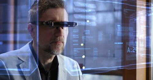 Man Using AR Glasses Examining Data on Screen