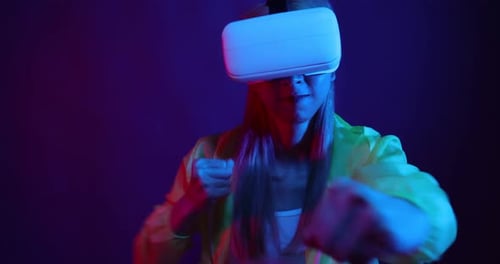 Young Asian woman playing metaverse virtual reality digital technology game with VR goggle.