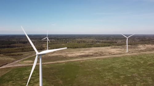 Wind Turbines Spinning in Green Field Aerial View
