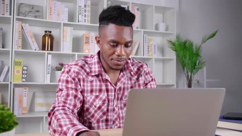 Man Working on Laptop at Desk at Home