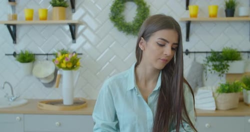 Woman Using Voice Assistant on Smartphone in Kitchen