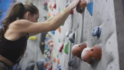 Sporty Girl Rock Climber Climbs the Climbing Wall