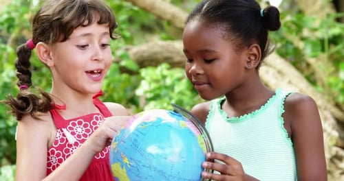 Schulkinder schauen sich den Globus auf dem Campus in der Schule an