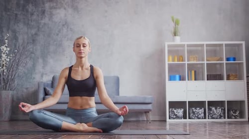 Blonde Woman Meditating in Lotus Pose at Home