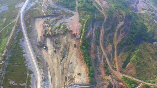 Aerial view of machine excavator trucks dig coal mining or ore with black grunge ground