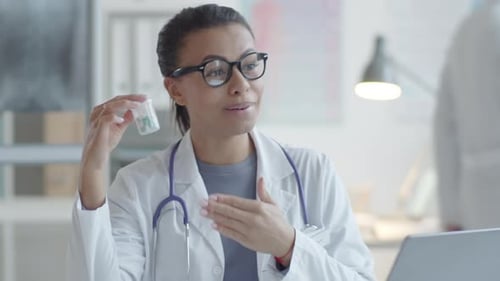 Doctor Holds Medication During a Telemedicine Video Call