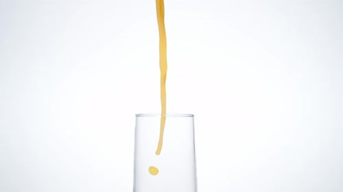 Orange Juice Pouring Into Glass With Ice