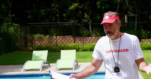 Lifeguard Giving Instructions by Outdoor Pool