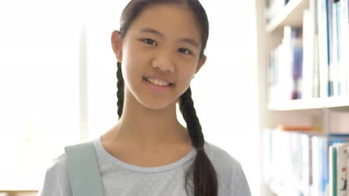 Asian teenager student holding books and backpack in school library for inspiration,Shoot with natur