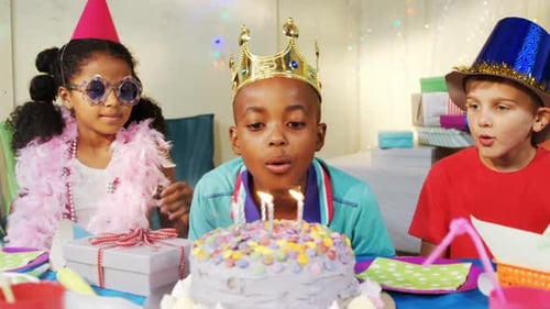 Boy blowing candles on cake during birthday