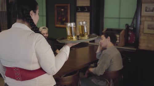 Hübsches pralles fettes Mädchen mit drei Gläsern Bier auf einem Tablett in einem Bierrestaurant