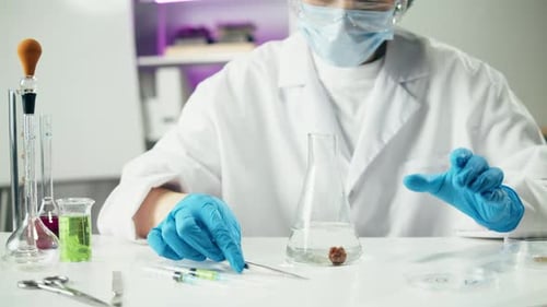 Scientifique médical inspectant la viande hachée portant un uniforme protecteur travaillant en laboratoire