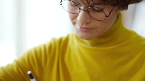 Young Adult Drawing at Table Indoors