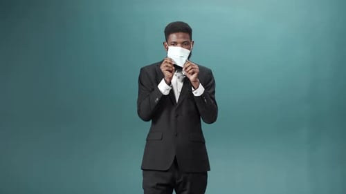 Man in Suit Puts on Face Mask and Approves