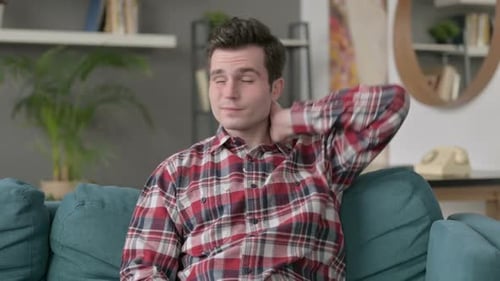 Young Adult Rubbing Aching Neck at Home