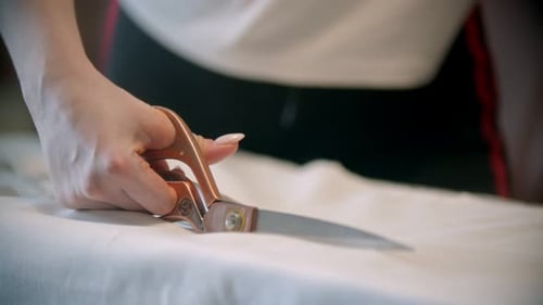 Woman Cutting White Fabric with Scissors Close Up