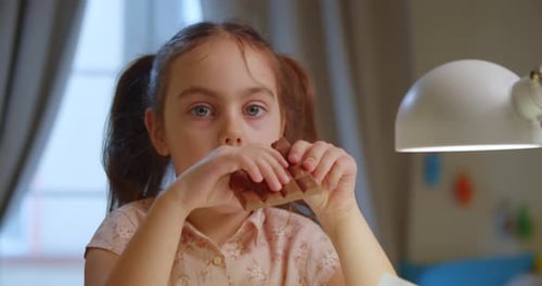 Cute Little Girl is Eating Chocolate While Enjoying a Delicious Treat