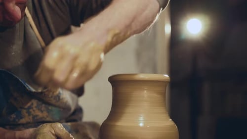 Potter Making Shape of Prepared Clay Vase in Workshop