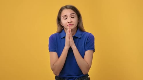 Portrait European Blonde Woman Asking Please with United Hands Posing Isolated on Orange Studio