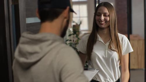 Woman Signs for Package Delivery at Front Door