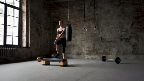 Woman Performs Step Aerobics in a Gym