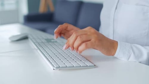 Woman Types on Keyboard in Modern Office