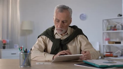 Senior Man Using Tablet Device in Bright Home