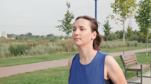 Woman Jogging in a City Park on Sunny Day
