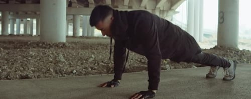 Man Doing Pushups on Urban Street