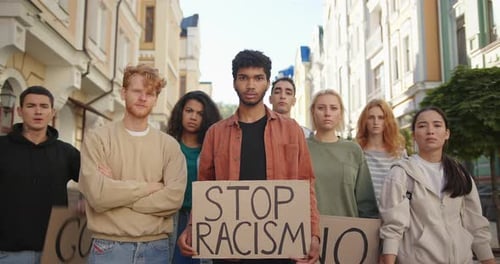 Multiracial Students on Public Demonstration at City Street Against Racism with Slogans on Posters