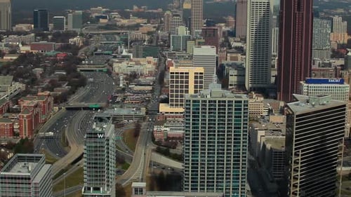 A high angle, pan shot from left to right of the Atlanta Skyline with cars on the freeway.