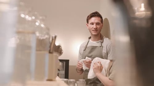 Team Wipes Glasses in Bright Restaurant Setting