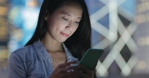 Woman using mobile phone at night