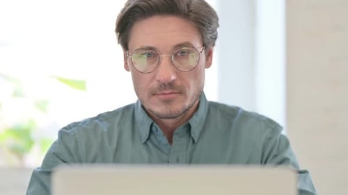 Man Smiling at the Camera While Working