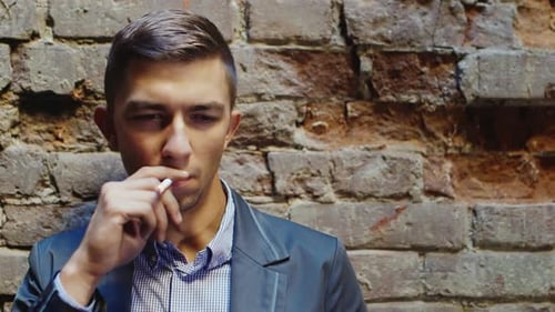 Jeune homme d'affaires frustré fume dans une maison abandonnée. Concept - Stress, Dépression, Problème