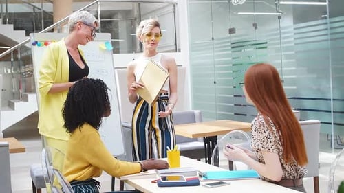 Diverse Women Collaborate on Project in Modern Office