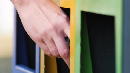 Hand Recycles Plastic Bottle in Urban Setting